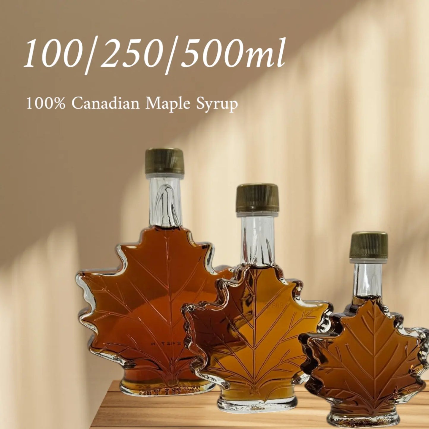 Three maple syrup bottles with maple leaf design on a wooden surface and beige background.
