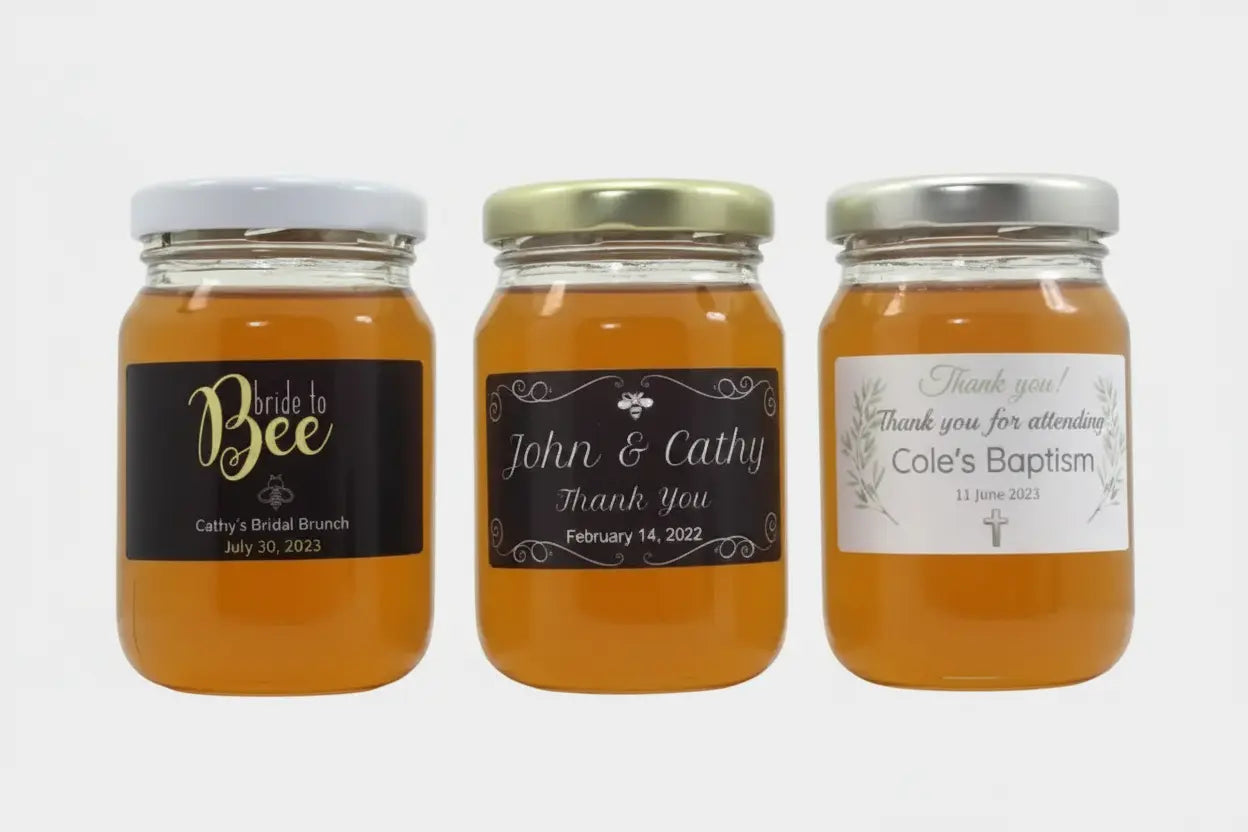 Three jars of honey with personalized labels on a white background